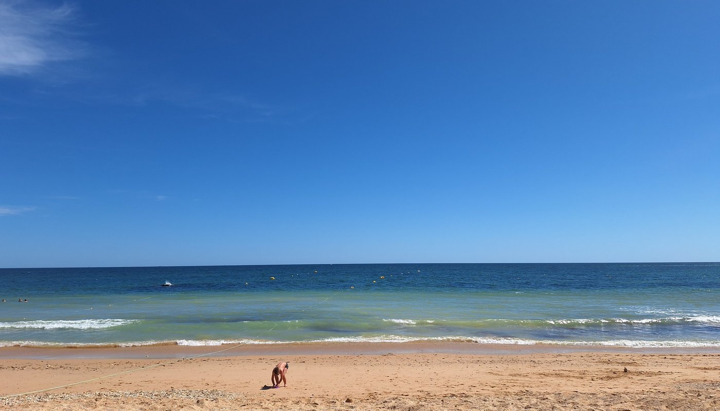 Een kind speelt aan de vloedlijn van het strand bij Santa Eulália